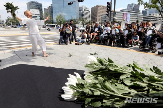 【서울=뉴시스】김병문 기자 = 23일 오후 서울 종로구 정부서울청사 앞에서 기초법바로세우기공동행동, 장애인과가난한이들의3대적폐폐지공동행동, 한국한부모연합 주최로 열린 '가난 때문에 세상을 떠난 관악구 모자의 추모제'에 참석한 이삼헌 무용가가 진혼무를 하고 있다. 2019.08.23. dadazon@newsis.com