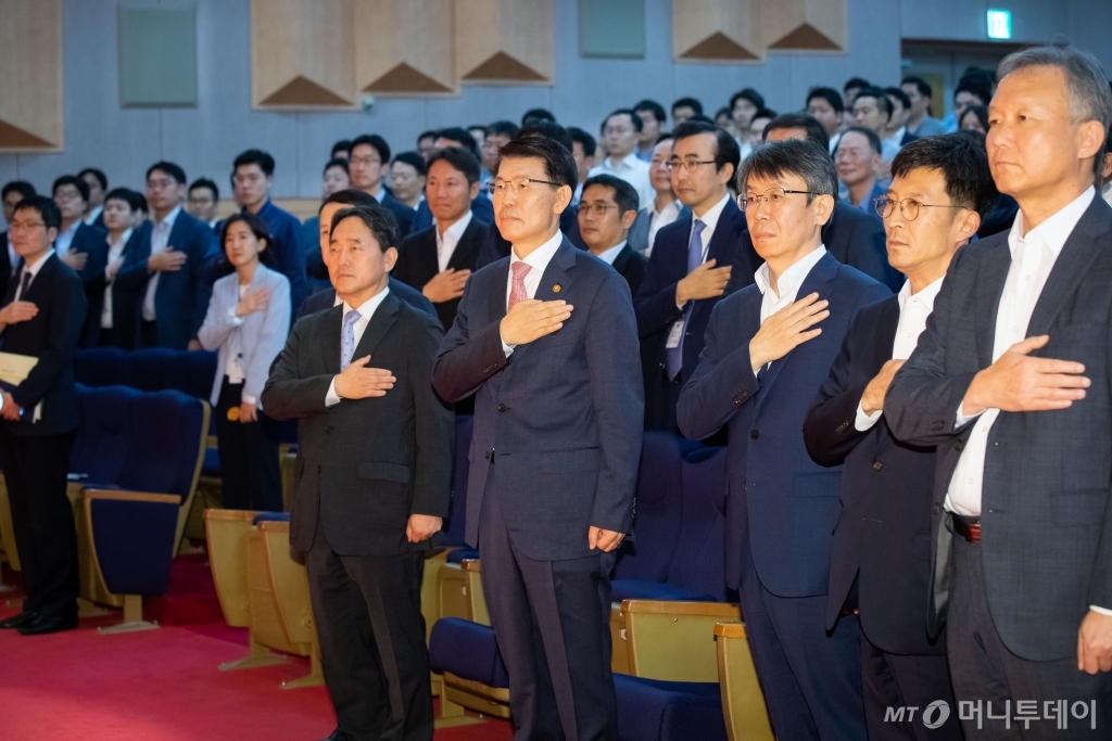 은성수 금융위원장(가운데)이 9일 열린 취임식에서 국기에대한 경례를 하고 있다./사진제공=금융위원회
