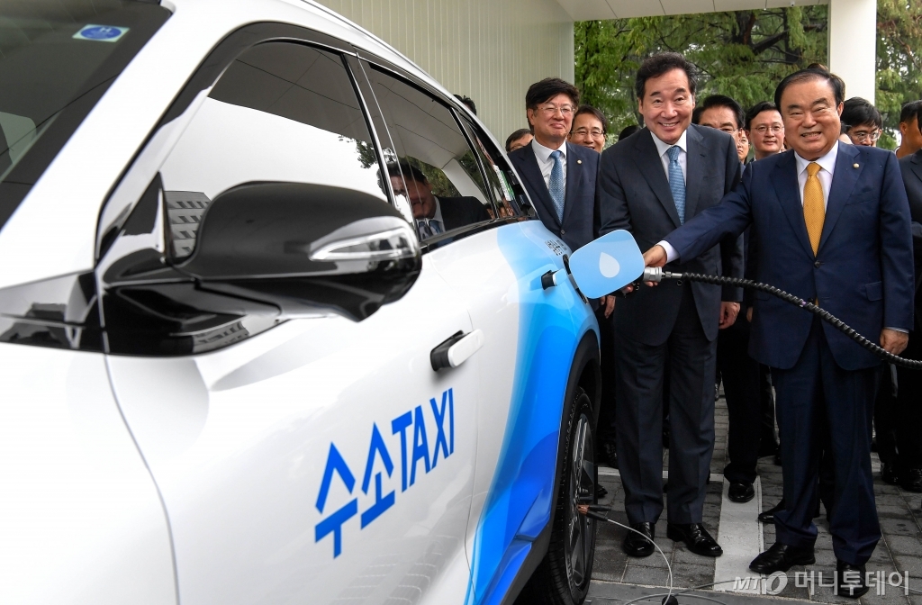 앞줄 오른쪽부터 문희상 국회의장, 이낙연 국무총리가 수소전기택시에 수소를 충전을 하는 모습/사진제공=현대자동차