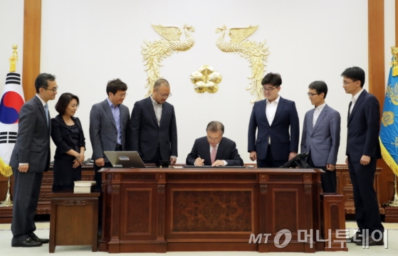 문재인 대통령이 지난 19일 청와대 본관 집무실에서 200만호 특허증 및 100만호 디자인등록증에 서명하고 있다./사진제공=청와대