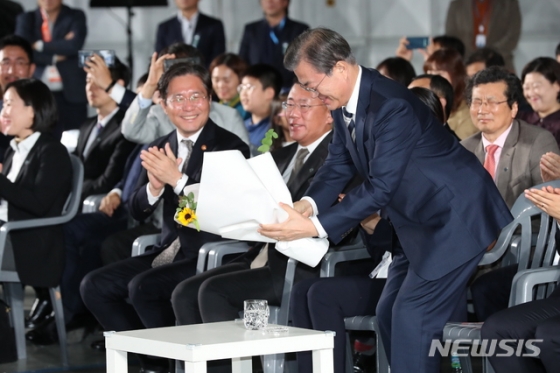 【화성=뉴시스】 박영태 기자 = 문재인 대통령이 15일 경기도 화성시 현대자동차 남양연구소에서 열린 미래차 산업 국가비전 선포식에 참석, 신재원 현대자동차 부사장으로부터 꽃다발을 받고 자리에 앉고 있다. 2019.10.15.   since1999@newsis.com