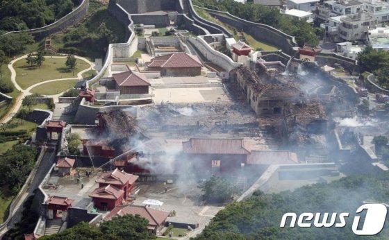 31일 (현지시간) 오키나와 나하에 있는 세계문화유산인 슈리성 터에 복원된 슈리성에서 화재가 발생해 중심 건물인 정전 등이 연기로 뒤덮인 모습이 보인다. /AFP=뉴스1