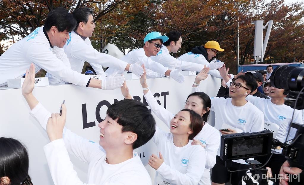 9일 오전 서울 영등포구 여의도 도심 일대에서 머니투데이,현대자동차 주최로 열린 '롱기스트 런 인 서울'에서 참가자들이 코스를 달리고 있다. 김의승 서울시 기후환경본부장(위 왼쪽부터), 장재훈 현대자동차 부사장, 김준형 머니투데이 편집국장이 출발점에서 참가자들과 하이파이브를 하고 있다./사진=김휘선 기자