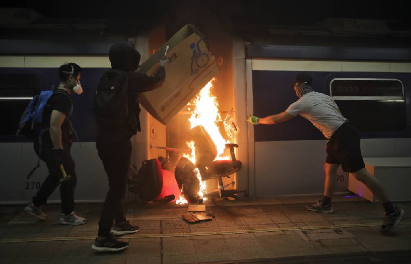 13일(현지시간) 홍콩의 중문대학 MTR 역 내에서 시위 학생들이 열차에 불을 지르고 있다./사진-=뉴시스