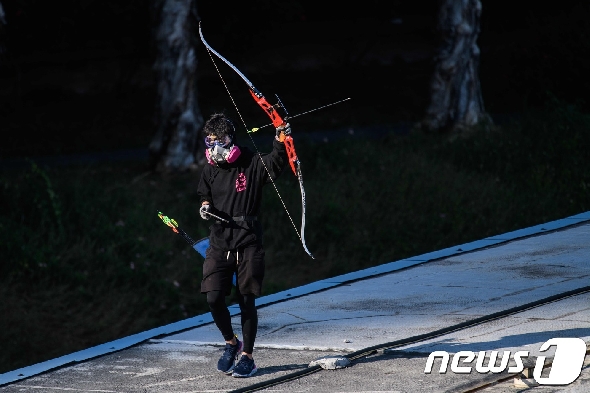16일(현지시간) 화살을 쏘며 걸어가고 있는 홍콩이공대 시위대. © AFP=뉴스1