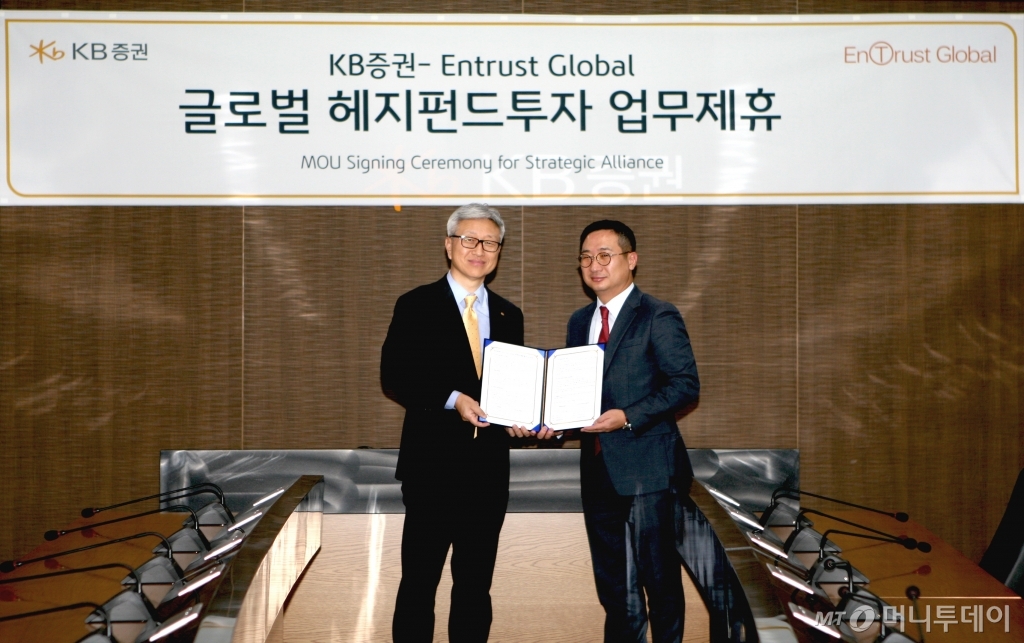 KB증권은 지난 22일 서울 여의도 본사에서 엔트러스트글로벌과 업무 제휴 계약을 체결했다. 협약식에 참석한 이형일 KB증권 총괄본부장(왼쪽)과 조영로 엔트러스트글로벌 전무가 사진 촬영을 하고 있다. /사진제공=KB증권