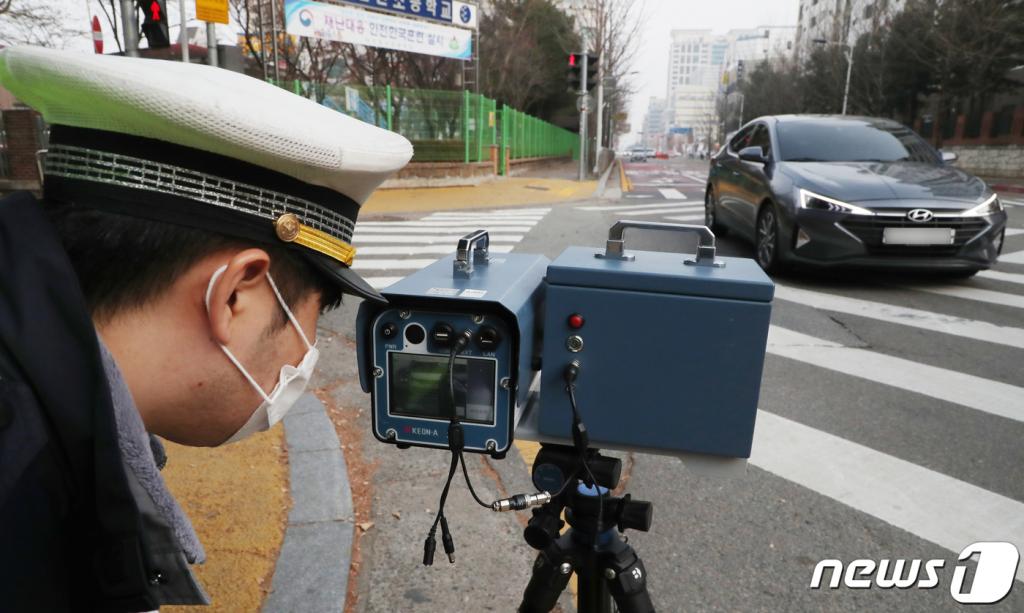 스쿨존 어린이 교통안전 강화를 위한 '민식이법'이 국회를 통과한 가운데 지난 11일 오후 대전 서구 둔산 초등학교 앞 스쿨존에서 둔산 경찰서 교통안전계 경찰이 과속단속 카메라를 설치해 과속 차량을 단속을 하고 있다.  대전시는 경찰과 '민식이법' 관련 예산이 반영되는 대로 과속단속 카메라 및 신호등 설치 등 사업을 추진할 계획이다. 충남도는 오는 2022년까지 도내 모든 어린이보호구역(스쿨존) 내에 자동차 무인과속단속카메라를 설치한다고 밝혔다./사진=뉴스1