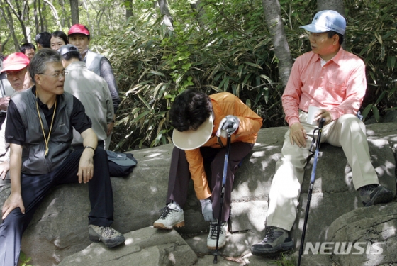 【서울=뉴시스】 노무현 전 대통령 10주기인 23일 노 전 대통령의 전속 사진사였던 장철영 씨가 청와대 재임과 퇴임 시 찍었던 대통령의 일상생활을 비롯한 미공개 사진 40여 점을 공개했다.   사진은 2007년 5월 노 전 대통령 부부가 5.18 기념식을 마친 다음 날 무등산 등산 도중 휴식을 취하며 당시 문재인 비서실장과 대화를 나누고 있다. 2019.05.23. (사진=사진가 장철영 제공)   photo@newsis.com