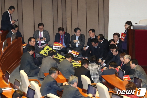 (서울=뉴스1) 임세영 기자 = 자유한국당 의원들이 27일 서울 여의도 국회 본회의장에서 제373회 국회(임시회) 제1차 본회의 개의를 막기위해 의장석을 둘러싸고 있다. 이날 국회에서는 선거법이 표결에 붙여질 예정이다. 2019.12.27/뉴스1   <저작권자 © 뉴스1코리아, 무단전재 및 재배포 금지>