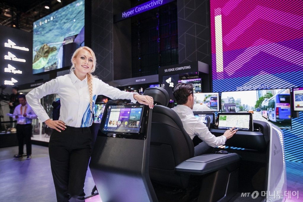 SK텔레콤 홍보모델들이 차량용 콕핏에 탑재된 통합 IVI(Integrated In-Vehicle Infotainment), HD맵 업데이트 기술을 적용한 로드러너 등을 선보이고 있다./사진제공=SK텔레콤