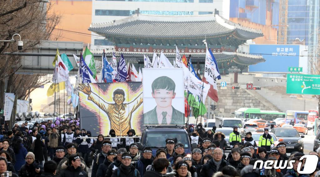 '청년 노동자' 고 김용균(24) 씨의 영정을 앞세운 운구행렬이 9일 오후 서울 종로구 세종대로에서 열린 노제를 마친 뒤 민주사회장 영결식이 열리는 광화문 광장을 향해 행진하고 있다. 고 김용균 씨는 지난해 12월 태안화력발전소에서 비정규직으로 일하다 컨베이어 벨트에 끼어 꽃다운 목숨을 잃었다. 그의 사망 후 원청의 책임을 강화해 하청노동자가 산재로부터 보호받을 수 있도록 하는 산업안전보건법이 개정되는 등 '위험의 외주화' 방지가 사회적 화두로 대두됐다. 2019.2.9/사진=뉴스1