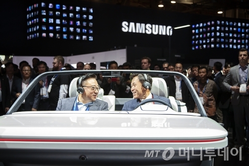 박정호 SK텔레콤 사장(오른쪽)이 8일 오전(현지시각) ‘CES 2019’ 전시장 내 삼성전자 부스에서 고동진 삼성전자 사장과 함께 '디지털 콕핏(Digital Cockpit) 2019'를 체험하고 있는 모습/사진제공=SK텔레콤