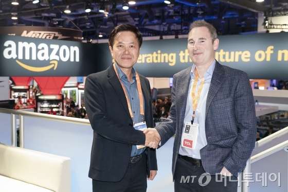 박정호 SK텔레콤 사장(왼쪽)이 CES 전시장 내 아마존 부스에서 앤디 제시(Andy Jassy) 아마존웹서비스(AWS) CEO와 악수를 하고 있다. 이날 SK텔레콤과 아마존웹서비스는 클라우드 사업 협력 방안을 논의했다./사진제공=SK텔레콤