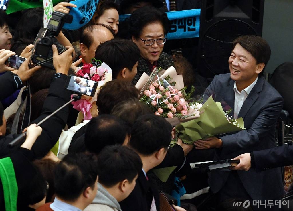  바른미래당 안철수 전 의원이 19일 오후 인천국제공항을 통해 귀국, 지지자들에게 꽃다발을 받고 있다. / 사진=홍봉진 기자 honggga@