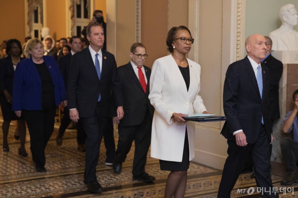 [워싱턴=AP/뉴시스] 미 하원 서기 셰릴 존슨(앞줄 왼쪽)이 15일(현지시간)워싱턴 국회의사당에서 하원을 통과한 도널드 트럼프 미 대통령 탄핵소추안을 들고 상원을 향해 걸어가고 있다. 존슨 뒤를 따르고 있는 사람들은 애덤 시프 민주당 하원 정보위원장 등 민주당이 선임한 탄핵소추위원들이다. 2020.01.16