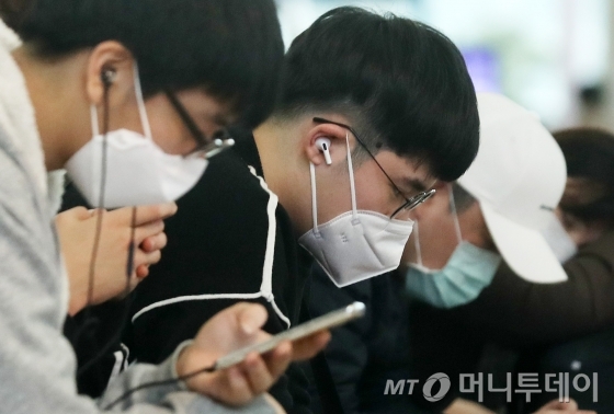 설 연휴 마지막 날인 27일 오후 인천국제공항 제1여객터미널 입국장에서 관광객 및 이용객들이 마스크를 쓴 채 대기하고 있다. / 사진=인천국제공항=김휘선 기자 hwijpg@