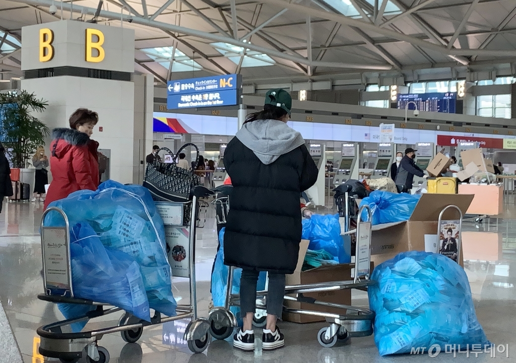 우한폐렴(신종 코로나바이러스 감염증) 확진자가 아시아를 넘어 유럽, 미주 등 전 세계로 확산되고 있는 28일 오후 인천국제공항 출국장에서 중국여행자들이 한국에서 구입한 마스크를 비닐봉투에 가득담아 출국수속을 기다리고 있다. /사진=뉴스1(독자제공)<br>