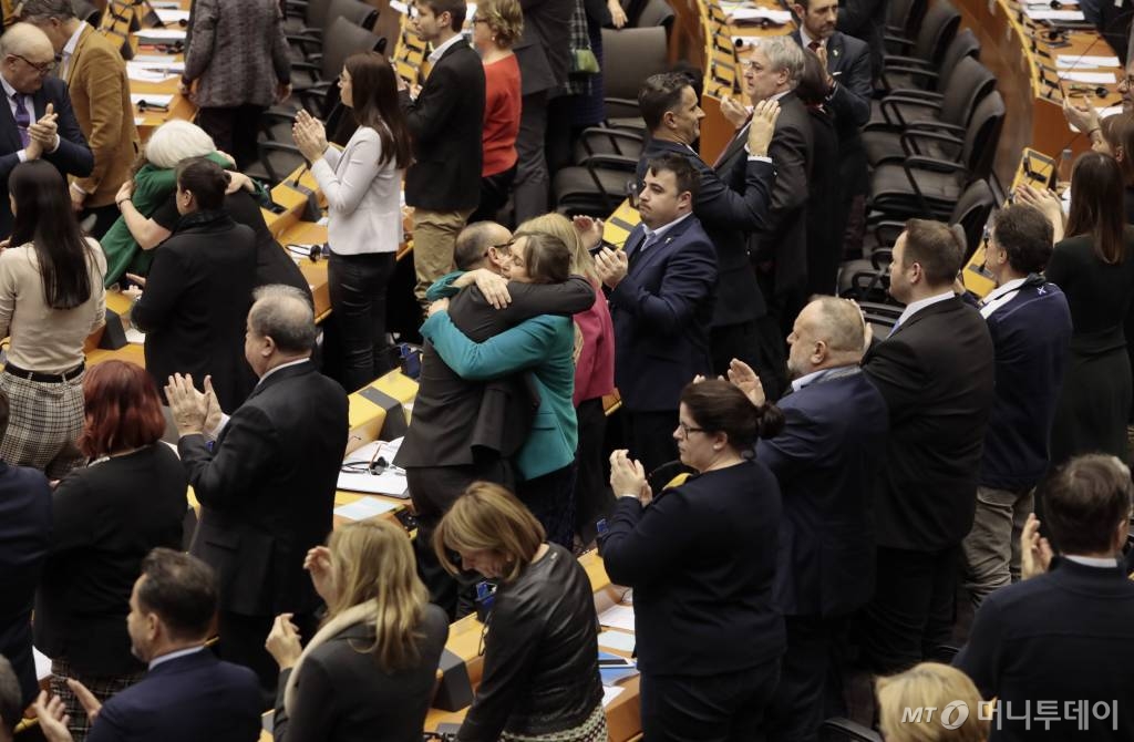 [브뤼셀=AP/뉴시스]29일(현지시간) 벨기에 브뤼셀에서 열린 유럽의회 총회에서 의원들이 브렉시트(영국의 유럽연합(EU) 탈퇴) 협정을 승인한 뒤 박수를 치고 포옹하고 있다. 영국은 31일 EU를 탈퇴한다. 2020.1.30.