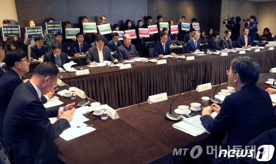 (서울=뉴스1) 민경석 기자 = 박능후 보건복지부 장관이 29일 오전 서울 중구 플라자호텔에서 열린 '국민연금기금운용위원회'에서 모두발언을 하고 있다.   박 장관 뒤로는 참여연대와 기후위기비상행동 등 시민단체 회원들이 국민연금이 최근 발표한 경영참여 목적의 주주권 행사 강화 가이드라인 보완과 ESG(환경·사회·거버넌스)를 고려한 투자에 나설 것을 촉구하고 있다. 2019.11.29/뉴스1  <저작권자 ⓒ 뉴스1코리아, 무단전재 및 재배포 금지>