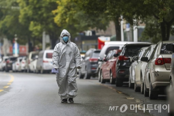 [우한=AP/뉴시스] 신종 코로나바이러스 진원지인 중국 후베이성 우한시에서 27일 보호장비를 착용한 의료진이 인적 끊긴 거리를 걷고 있다. 2020.01.28.