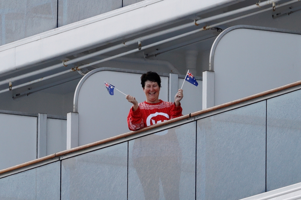 한 승객이 호주 국기를 들어보이며 웃고 있다. /사진=로이터