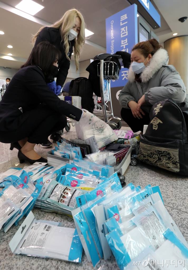  보따리상에 의한 마스크와 손 세정제의 대량 반출 차단을 위한 수출절차가 강화된 6일 인천국제공항 출국장에서 세관 관계자들이 출국자들의 여행가방에 담긴 마스크의 수량을 확인하고 있다. 정부는 이날부터 마스크 301~1000개 이하는 간이수출신고, 200만원 초과이거나 1,000개를 넘으면 정식수출신고 대상으로 규제를 강화했다. / 사진=이기범 기자 leekb@