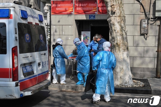 (우한 AFP=뉴스1) 우동명 기자(우한 AFP=뉴스1) 우동명 기자 = 30일 (현지시간) 신종 코로나바이러스인 ‘우한폐렴’ 발원지인 후베이성 우한의 한 아파트에서 의료진이 의심환자를 이송하고 있다. ⓒ AFP=뉴스1 <저작권자 ⓒ 뉴스1코리아, 무단전재 및 재배포 금지>