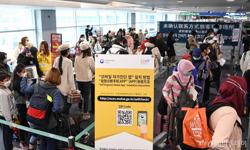 홍콩과 마카오가 코로나19 오염지역으로 지정돼 2개국에 대한 특별입국절차가 개시된 13일 인천국제공항에서 홍콩발 항공편 탑승객들이 자가진단 앱을 설치를 위해 줄지어 서 있다. 기사내용과 무관./사진=공항사진기자단