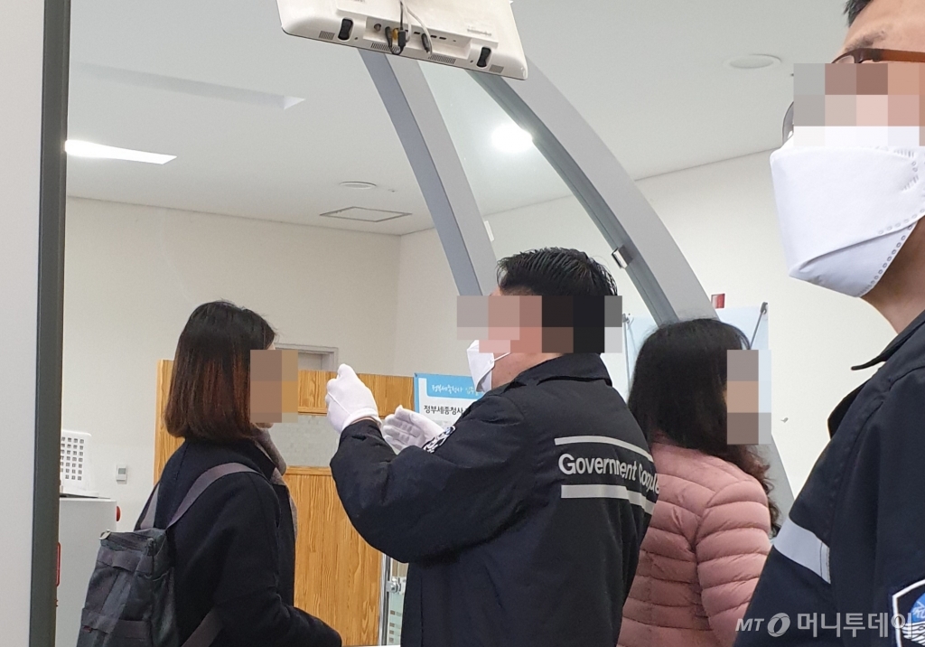 24일 정부세종청사 13동 산업통상자원부 출입구에서 청원경찰이 체온계로 출입자들의 체온을 재고 있다./사진=권혜민 기자