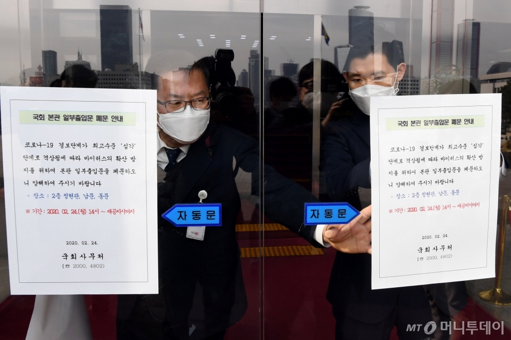 국회 관계자가 24일 오후 서울 여의도 국회 의원회관 2층 안내실 출입구 폐문을 알리는 안내문을 부착하고 있다. /홍봉진 기자
