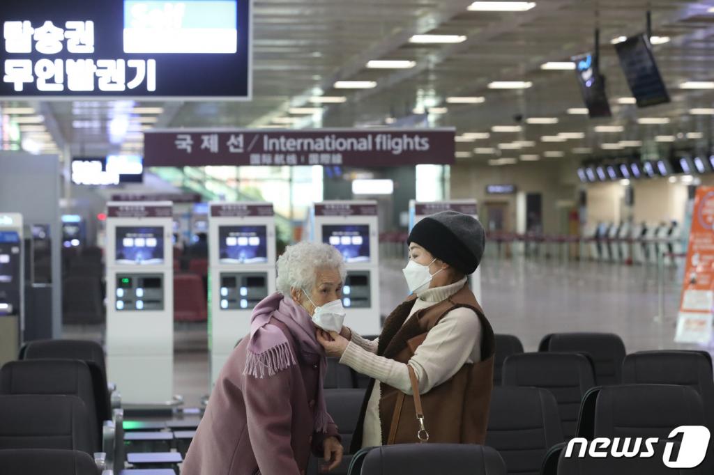 (대구=뉴스1) 공정식 기자 = 신종 코로나바이러스 감염증(코로나19) 확산에 대구∼제주 노선을 비롯한 일부 항공사의 운항이 중단되고 일부 항공편이 결항하는 등 대구국제공항에 찬바람이 부는 가운데 24일 오후 공항 대합실에서 딸이 어머니의 마스크를 씌워주고 있다. 2020.2.24/뉴스1 <저작권자 © 뉴스1코리아, 무단전재 및 재배포 금지>