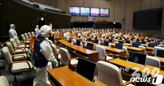 (서울=뉴스1) 김명섭 기자 = 25일 오전 서울 여의도 국회 본관 본회의장에서 코로나19 방역 관계자들이 방역작업을 하고 있다. 국회는 신종 코로나바이러스 감염증(코로나19) 확산 사태와 관련, 24일 오후 6시부터 26일 오전 9시까지 국회 본관과 의원회관을 폐쇄하기로 했다. 국회가 감염병 때문에 폐쇄되는 것은 이번이 사상 처음이다.(국회사무처 제공) 2020.2.25/뉴스1