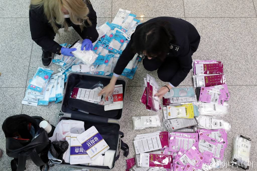  보따리상에 의한 마스크와 손 세정제의 대량 반출 차단을 위한 수출절차가 강화된 6일 인천국제공항 출국장에서 세관 관계자들이 출국자들의 여행가방에 담긴 마스크의 수량을 확인하고 있다. 정부는 이날부터 마스크 301~1000개 이하는 간이수출신고, 200만원 초과이거나 1,000개를 넘으면 정식수출신고 대상으로 규제를 강화했다. / 사진=이기범 기자 leekb@