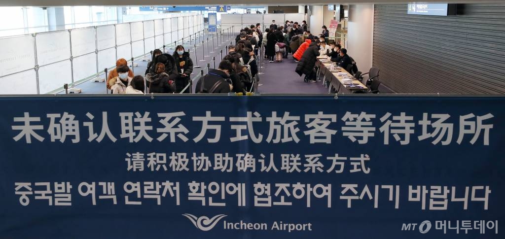 인천국제공항 제1터미널 중국발 항공기 전용 입국장에서 탑승객들이 국내 연락 가능한 연락처를 확인받고 있다. / 사진=이기범 기자 leekb@