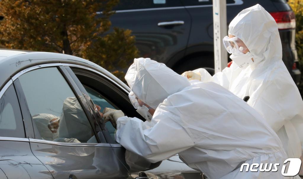 지난 26일 세종시 조치원읍 세종시보건소에 설치된 코로나19 선별진료소에서 방역당국 관계자들이 검체를 차량에 탑승한 시민에게 검체를 채취하고 있다./사진=뉴스1