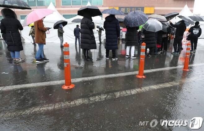 (경산=뉴스1) 공정식 기자 = 신종 코로나바이러스 감염증(코로나19) 확산으로 대구·경북 지역에서 마스크 대란이 벌어지는 가운데 25일 오전 이마트 마스크 2차 물량 판매를 앞두고 이마트 경산점에서 마스크를 사려는 시민들이 우산으로 비를 피하며 줄을 서 있다. 이마트 측은 "시민 안전을 최우선으로 고객 불편을 줄이기 위해 이날 오전 보유 중인 마스크 수량만큼 교환권을 배부해 오전 10시부터 오후 6시까지 자유롭게 마스크를 살 수 있도록 했다"며 "교환권 배부로 다행히 어제보다 혼잡이 줄어들었다"고 말했다. /사진=뉴스1