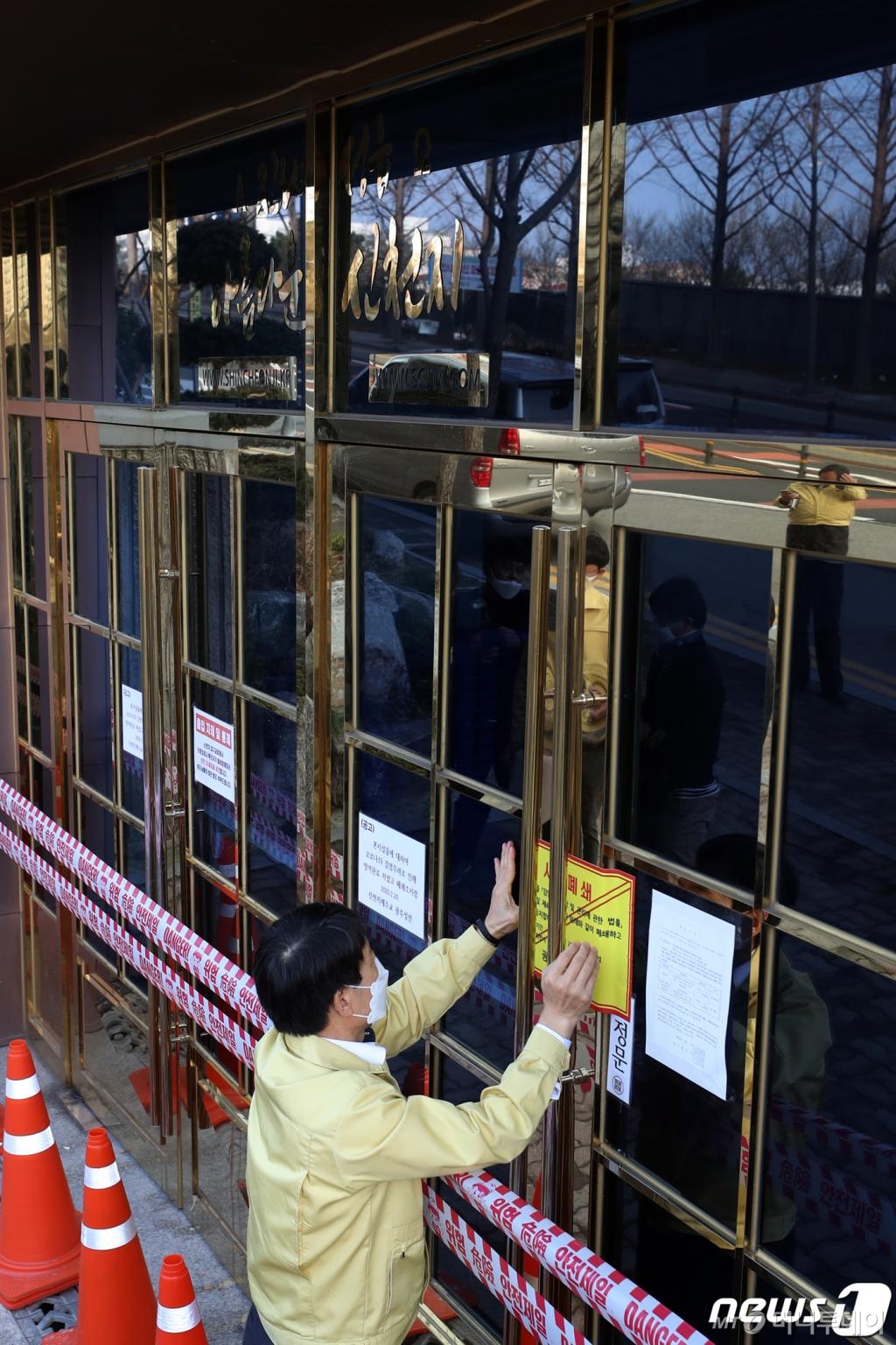 (광주=뉴스1) 황희규 기자 = 광주시와 북구청 관계자들이 27일 오후 광주 북구 오치동 신천지 베드로지성전(광주교회) 출입문에 시설 폐쇄를 알리는 행정처분서를 붙이고 있다.2020.2.27/뉴스1 <저작권자 © 뉴스1코리아, 무단전재 및 재배포 금지>