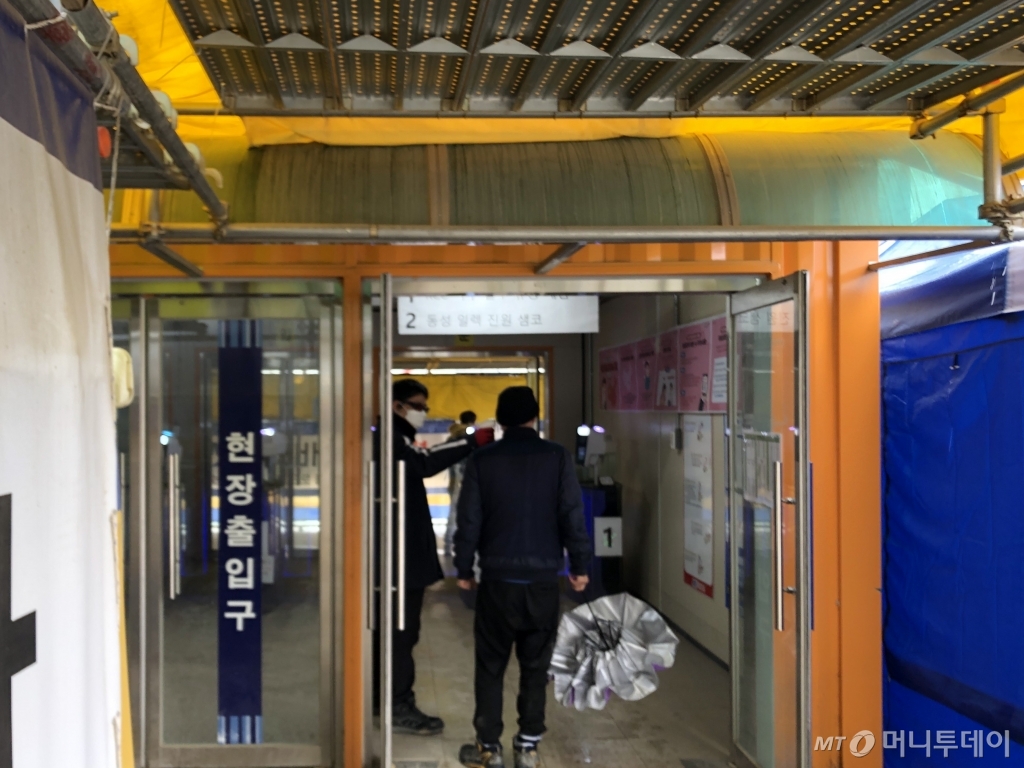 삼성전자 평택캠퍼스 사무2동 신축공사장 출입구에서 보안요원이 비접촉식 체온계로 체온을 재고 있다/사진=이정혁 기자