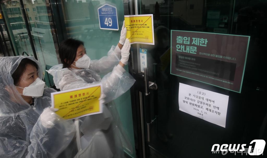 25일 신종 코로나바이러스 감염증(코로나19) 울산 확진자가 4명으로 늘어난 가운데 울산시청 공무원들이 남구 무거동 신천지 울산교회 출입문에 폐쇄명령서를 붙이고 있다. 울산시는 '감염병의 예방 및 관리법 제47조와 제49조에 따라 신천지 울산교회 본관과 부속기관 19곳 등 모두 20곳을 3월9일까지 2주간 폐쇄한다고 밝혔다./사진=뉴스1