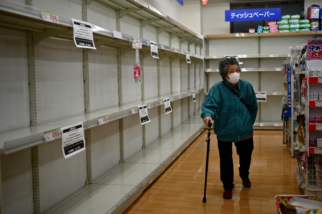 일본 도쿄의 한 상점에서 한 여성이 텅빈 화장지 진열대를 지나가고 있다./사진=AFP
