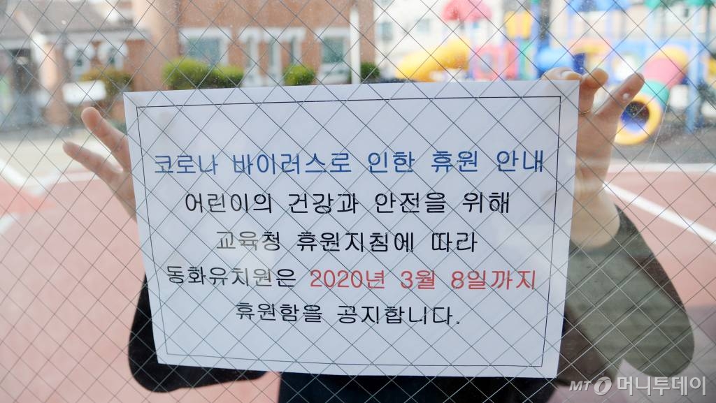 [전주=뉴시스] 김얼 기자= 코로나19의 감염 확산을 미연에 방지하기 위해 전국의 어린이집과 유치원이 휴원한 27일 전북 전주시 덕진구 동화유치원에서 교사가 휴원 안내문을 붙이고 있다. 2020.02.27.  pmkeul@newsis.com