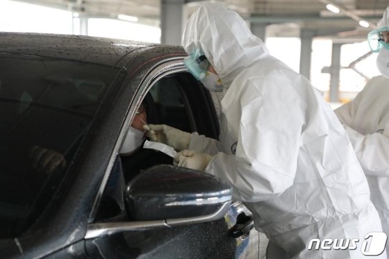 광주=뉴스1) 허단비 기자 = 28일 오후 광주 북구 용봉동 북구보건소 인근 효죽공영주차장에 마련된 '드라이브 스루(Drive through·지나가기) 선별진료소'에서 보건소 직원이 검체 채취 시범을 보이고 있다.2020.2.28/뉴스1 <저작권자 © 뉴스1코리아, 무단전재 및 재배포 금지>