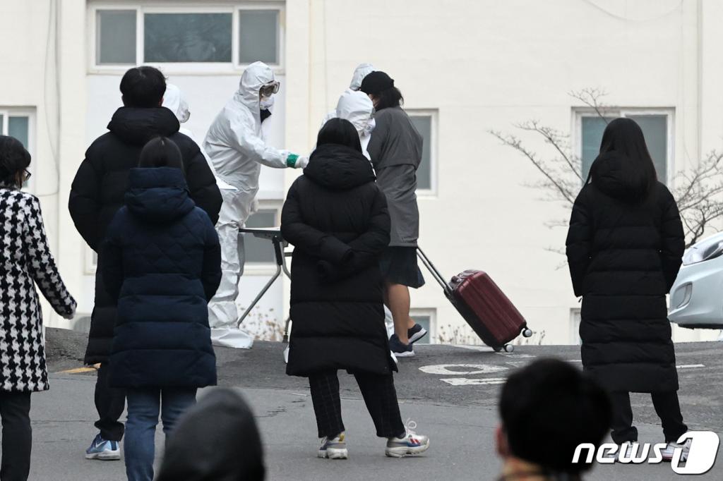 (대구=뉴스1) 이승배 기자 = 8일 오전 대구시 달서구 신종 코로나바이러스 감염증(코로나19)으로 처음으로 코호트격리된 한마음아파트에서 한 확진자가 캐리어를 끌고 생활치료센터행 버스로 향하고 있다. 국내에서 처음으로 코로나19로 코호트격리된 이 아파트에는 입주민 142명 중 확진자가 46명이 나왔다. 또한 입주민 중 66.19%인 94명이 신천지 교인으로 알려졌다. 2020.3.8/뉴스1