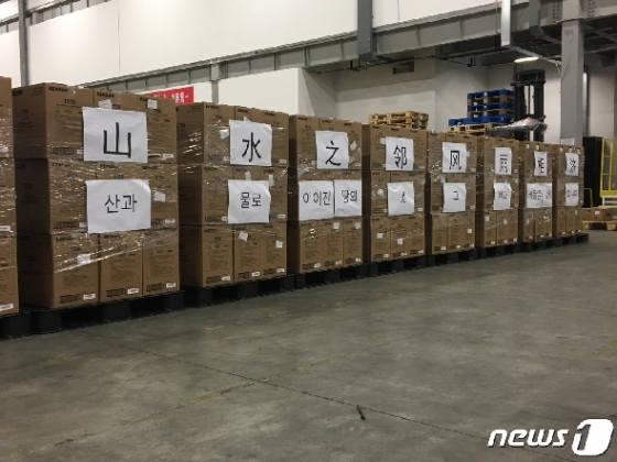 지난 7일 중국 자싱시에 위치한 알리바바그룹 산하 차이냐오(菜鸟网络)의 창고에서 알리바바 마윈이 기증한 마스크 100만장이 한국으로 출발하기 전 적재돼 있는 모습. '산수지린, 풍우상제(山水之邻，风雨相济, 가까운 이웃끼리 도와 어려운 시기를 이겨낸다)'이란 문구가 상자에 붙어 있다. (사진=대한적십자사 제공=뉴스1).