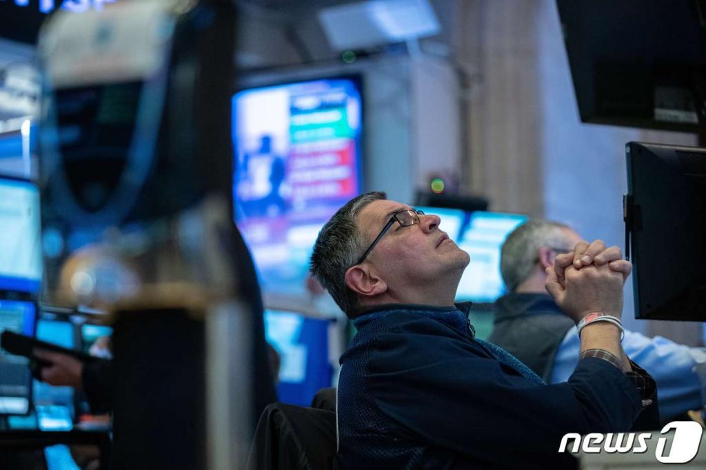 (뉴욕 AFP=뉴스1) 우동명 기자 = 11일(현지시간) WHO가 코로나19을 '팬데믹'으로 선언하면서 투자심리가 크게 위축돼 뉴욕증시가 또다시 폭락하자 트레이더가 전광판을 보며 기도하는 모습을 하고 있다.   ⓒ AFP=뉴스1