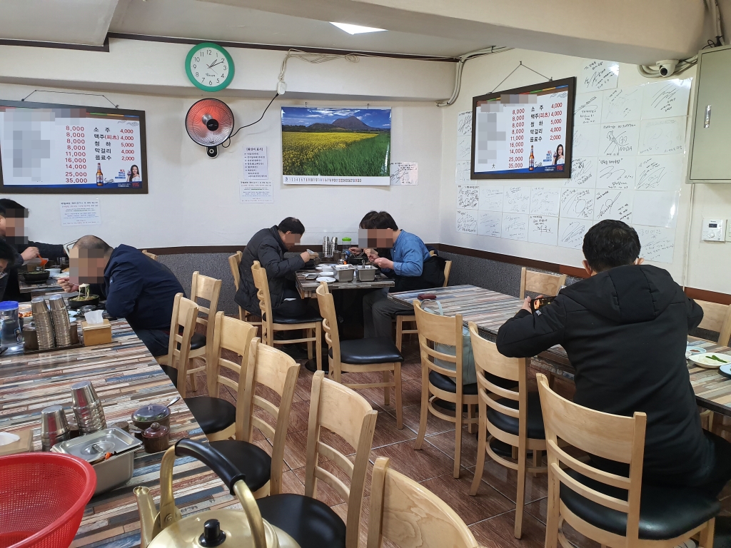지난 13일 오후 1시10분쯤 서울 마포구 한 국밥집에서 손님들이 식사를 하고 있다. 지난 6일 코로나19 확진자가 다녀간 이 식당의 일매출은 평소의 6분의1 수준으로 떨어졌다. 한쪽 벽에 유명인사들의 싸인이 평소 인기 있던 식당임을 알려주고 있다. /사진=백지수 기자