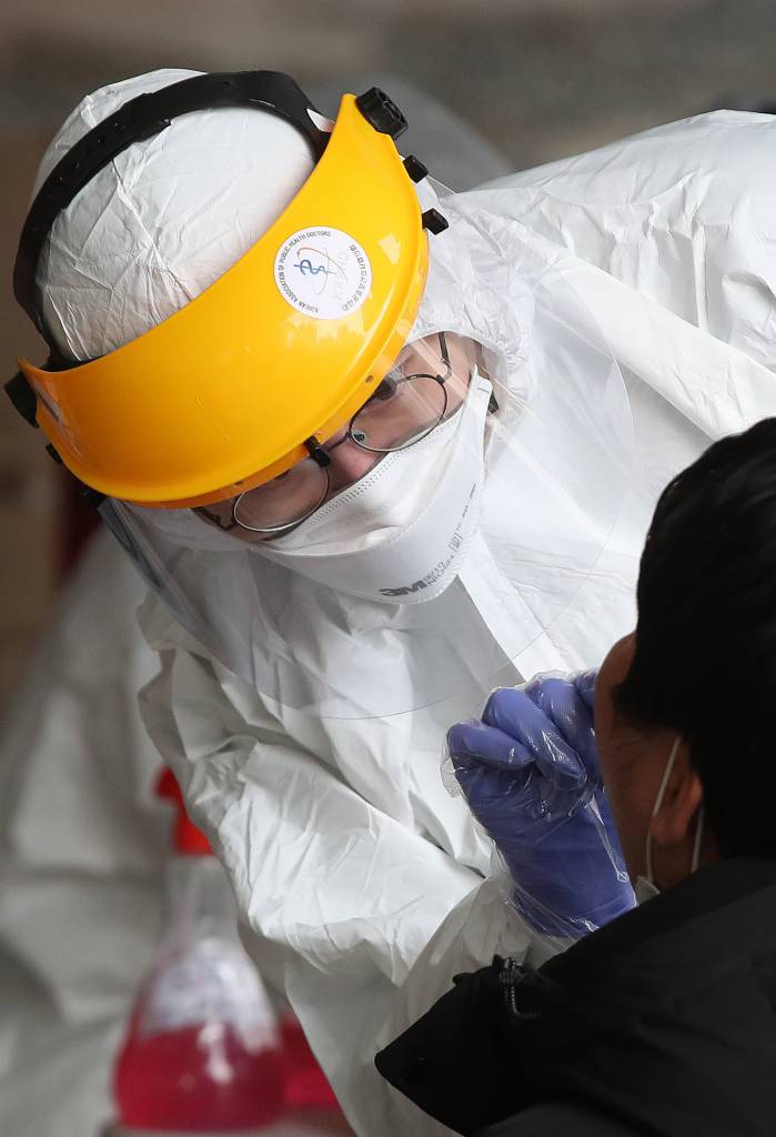 [서울=뉴시스]김선웅 기자 = 12일 코로나19 집단 감염 발생 콜센터가 위치한 서울 구로구 코리아빌딩 앞에 설치된 선별진료소에서 의료진이 의심환자 검체를 채취하고 있다. 한편 세계보건기구(WHO)는 코로나19의 팬데믹(세계적 대유행)을 선언했다. 2020.03.12.   mangusta@newsis.com