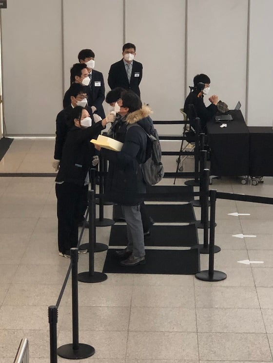 삼성전자 주총이 열린 수원컨벤션센터에서 진행요원들이 주주들의 체온을 재고 있는 모습/사진=이정혁 기자