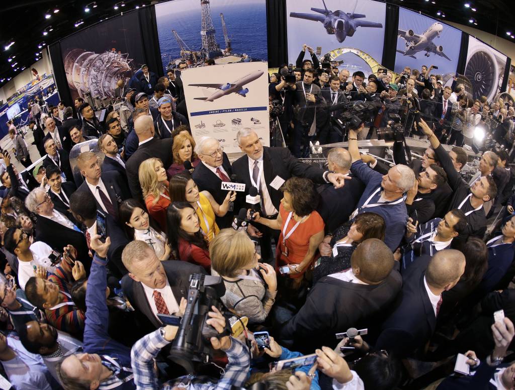 워런 버핏 버크셔해서웨이 회장(가운데 왼쪽)이 2016년 4월30일(현지시간) 미국 네브라스카주 오마하에서 열린 버크셔의 연례 주주총회에서 취재진에 휩싸인 채 미국 고강도 금속부품업체 프리시전캐스트파트의 제품을 바라보고 있다. 버크셔는 지난해 8월 프리시전을 인수했다. 1949년에 설립된 프리시전은 보잉과 에어버스 등 주요 항공업체에 제트엔진 터빈 날개 등을 공급한다. 오마하(미국)=AP / 사진제공=뉴시스