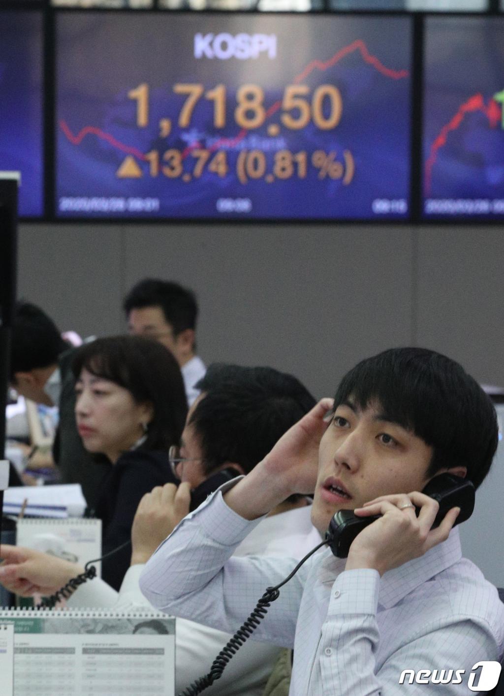 (서울=뉴스1) 신웅수 기자 = 26일 오전 서울 중구 하나은행 명동점 딜링룸에서 직원들이 근무를 하고 있다.  뉴욕증시의 주요 지수들이 2월 이후 처음으로 이틀 연속 상승 마감하면서 코스피와 코스닥도 이날 장 초반 강보합세를 보이고 있다. 2020.3.26/뉴스1